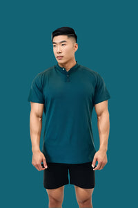 Titan Blue short sleeve golf shirt with black shorts on a teal backdrop