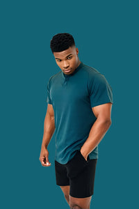 Titan Blue short sleeve golf shirt worn with black shorts, hand in pocket