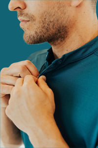 Close-up of the button placket and stand collar on the Titan Blue golf shirt