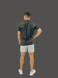 Back view of the Volcanic Ash short sleeve golf shirt with light grey shorts