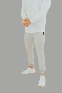 Pebble Grey men's golf joggers with a white long sleeve shirt and white sneakers