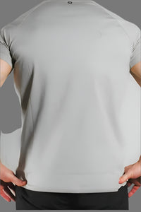 Back of a Sandstone Grey short sleeve gym shirt, model's hands at the waist