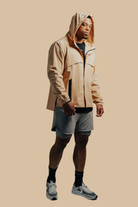 Man in a sand-colored King's Gold Stealth jacket with hood up