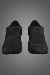 Top-down view of black camo low-cut training socks on grey