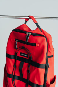 Kingdom Red Ai1 gym backpack detail: front zip pockets, bungee cord and compression straps