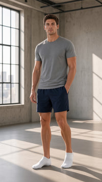 Man in a grey tee and navy shorts wearing white Explosion ankle socks