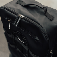 Close-up of the top handle and double zippers on the Midnight Black Ai1 gym backpack