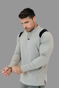 Man adjusting the cuff of a Ghost Grey long sleeve golf shirt with black shoulder panels
