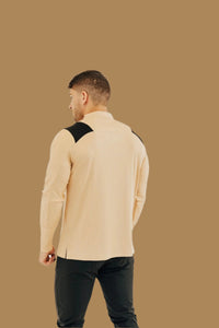 Back view of the King's Gold/Black long sleeve golf shirt on a tan backdrop