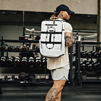 White gym backpack with black straps worn in a weight room, man in a black cap
