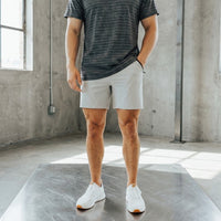 Front view of light grey 6 inch inseam golf shorts, hand resting in the side pocket