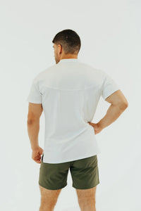 Blizzard White golf shirt from behind, hand on hip, showing the back yoke seam