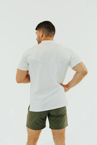 Blizzard White golf shirt back view, hands on hips, split hem visible