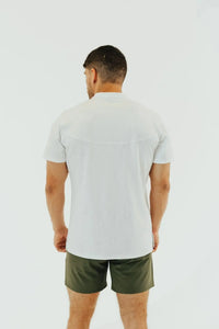 Back view of a Blizzard White short sleeve golf shirt worn with olive shorts