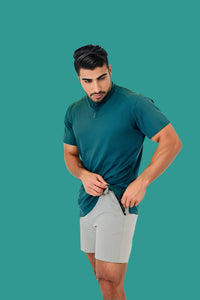 Man fastening the placket of a Pine Green short sleeve golf shirt