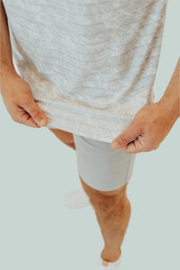 Hands holding the hem of the Snowstorm golf shirt to show the fabric texture