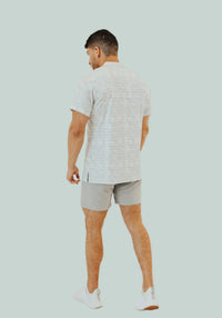 Back view of the Snowstorm golf shirt with light grey shorts and white sneakers