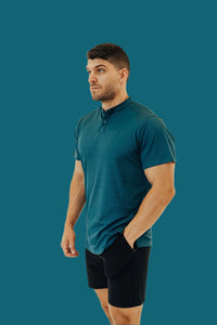 Man in the Titan Blue short sleeve golf shirt looking to the side