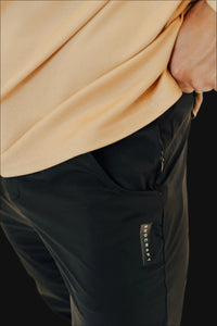 Zip side pocket and branded tab on Midnight Black golf joggers