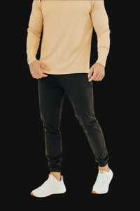 Front view of Midnight Black golf joggers worn with a tan long sleeve golf shirt