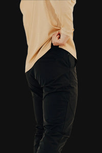 Side profile of Midnight Black golf joggers, thumb hooked in the pocket