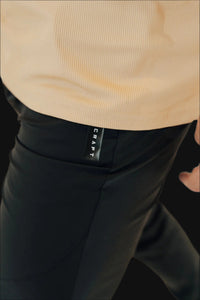 Detail of the side pocket zip and woven tab on black golf joggers