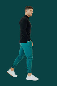 Side view of Pine Green golf joggers mid-walk, ankle cuffs