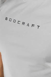 Extreme close-up of the BODCRAFT wordmark print on the Sandstone Grey shirt