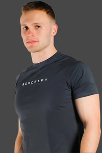 Man wearing a Shadow Grey short sleeve training shirt, 3/4 angle with face