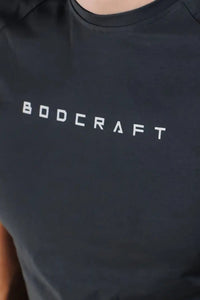 Close-up of the BODCRAFT chest logo on a Shadow Grey short sleeve workout shirt