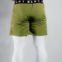 Back view of a shirtless model in Army Green training shorts over white leggings