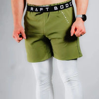 Front view of a shirtless model in Army Green training shorts, BodCraft waistband text visible