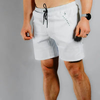 Front view of a shirtless model in white BodCraft training shorts with drawstring waist