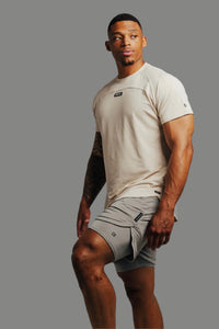 Ghost Grey Ai1 lined training shorts with a sand-colored tee, grey backdrop