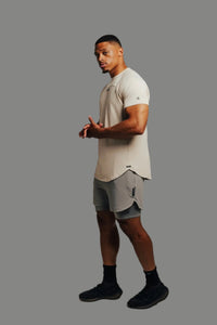 Man in Ghost Grey Ai1 lined shorts and a sand tee, three-quarter view