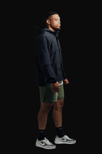 Side view of the Midnight Black Ai1 Stealth full-zip with olive shorts