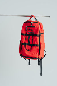 Kingdom Red Ai1 gym backpack with shoe compartment, full front view hanging on a rail