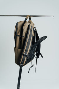 Olive Ai1 backpack side view with the laptop section zipped open against a grey backdrop